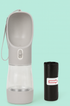 Gray portable dog water bottle with attached wrist strap and three black poop bag rolls with white and red labels.