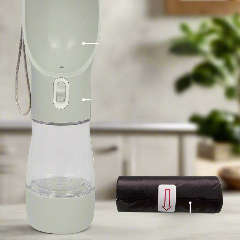Light gray portable pet water bottle with attached leash and black poop bag roll on neutral background.