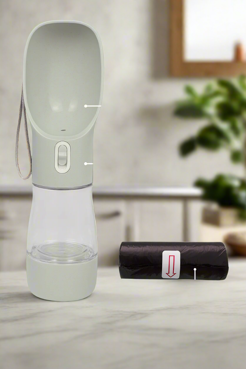 Light gray portable pet water bottle with attached leash and black poop bag roll on neutral background.